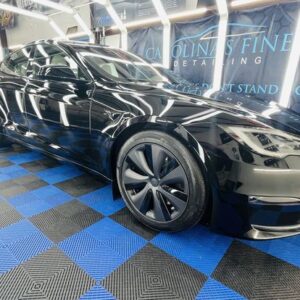 Black Tesla inside of a detail shop