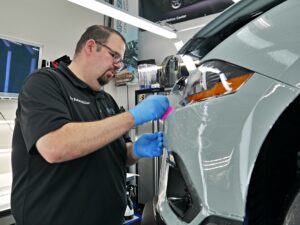 Applying PPF meticulously to a car bumper